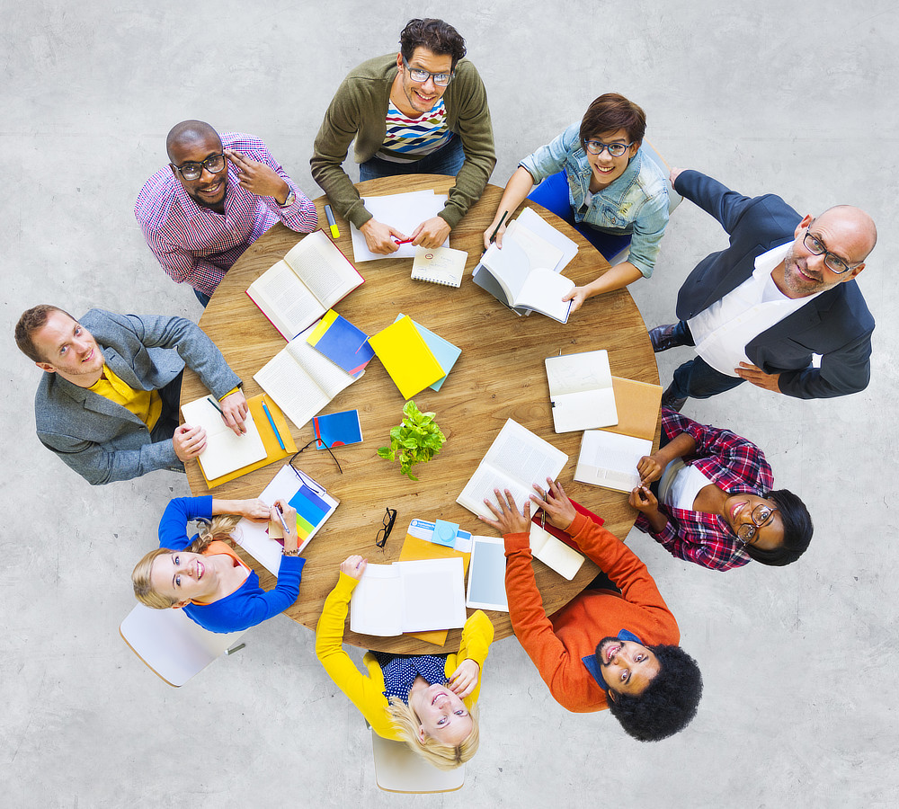 Photo of a group of people around a table from above.